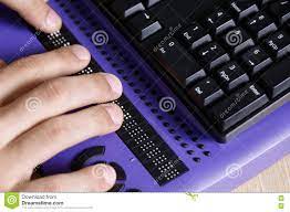 انگشتان دست فرد آسیب‌دیده بینایی در حال کار با کامپیوتر با استفاده از نمایشگر بریل