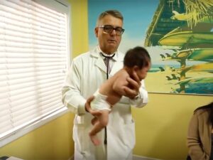 پزشکی که نوزادی را روی دست دارد