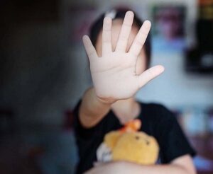 کودکی کف دست خود را جلوی صورت و به سمت دوربین گرفته و صورت کودک در تصویر مشخص نیست