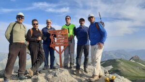 اعضای تیم کوهنوردی در قله قولی‌زلیخا و در کنار تابلوی این قله