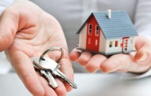 دو دست که در یکی از آنها کاردستی خانه و در دیگری چند کلید است