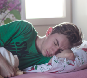 آقایی به پهلو خوابیده و یک دست را زیر سرش گذاشته