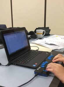 فرد نابینا در حال کار با لپ‌تاپ و نمایشگر بریل