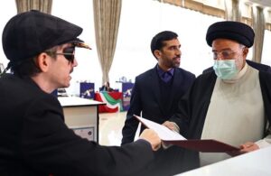 در حاشیه مراسم بزرگداشت روز معلولین، فردی پوشهای به آقای رئیس جمهور داده و وی به آن نگاه میکند