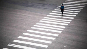 خانم نابینا با عصای سفید روی خط عابر پیاده