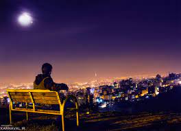 فردی نشسته روی نیمکت در محوطه بام تهران