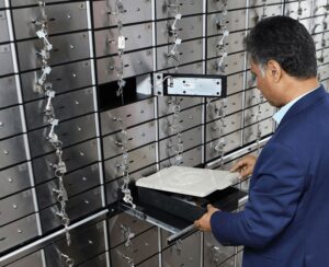 آقایی در بخش صندوق های امانت بانک ایستاده 