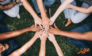 افراد بهصورت دایره نشستهاند و دستهایشان را جلو آورده و روی دست هم گذاشتهاند